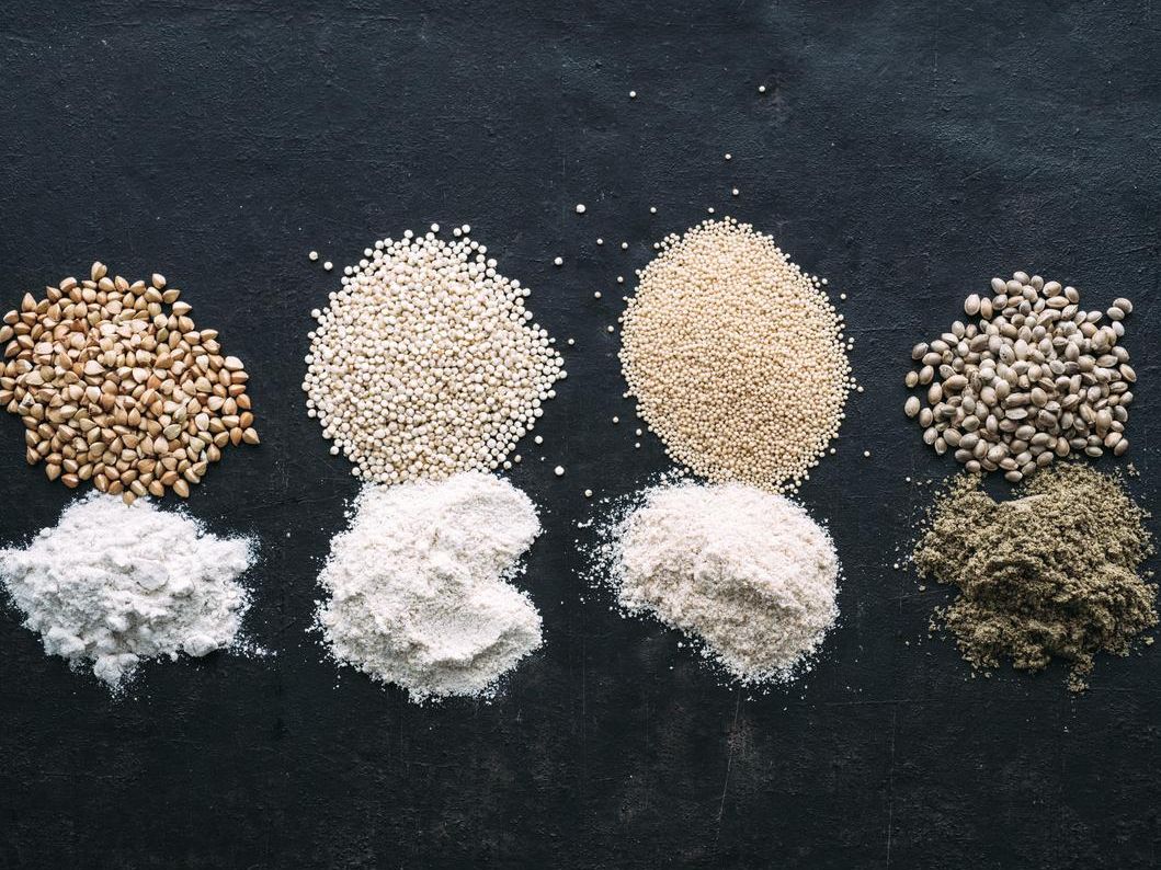 Zu sehen von links nach rechts Buchweizen, Quinoa, Amarant und Hanfsamen nebst zugehörigem Mehl